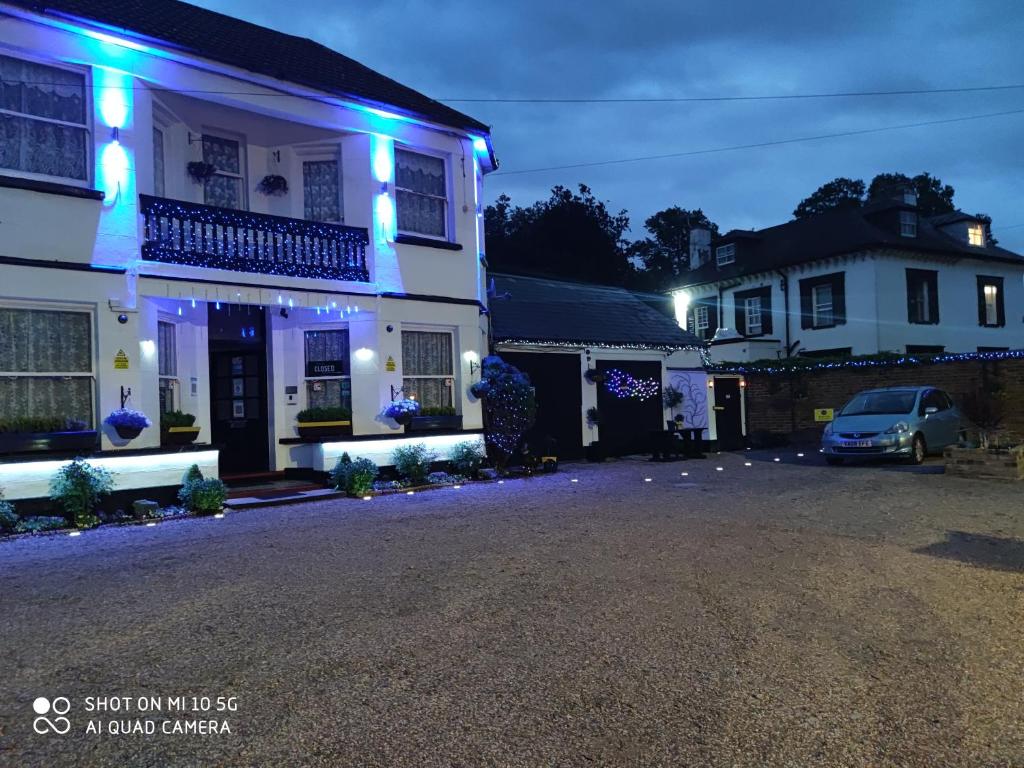 斯勞的住宿－Sussex Lodge Guest House，白色的房子,上面有蓝色的灯光