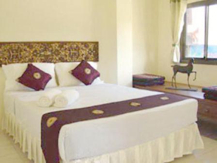 a bedroom with a large bed with purple pillows at Penzy Guest House in Chaweng