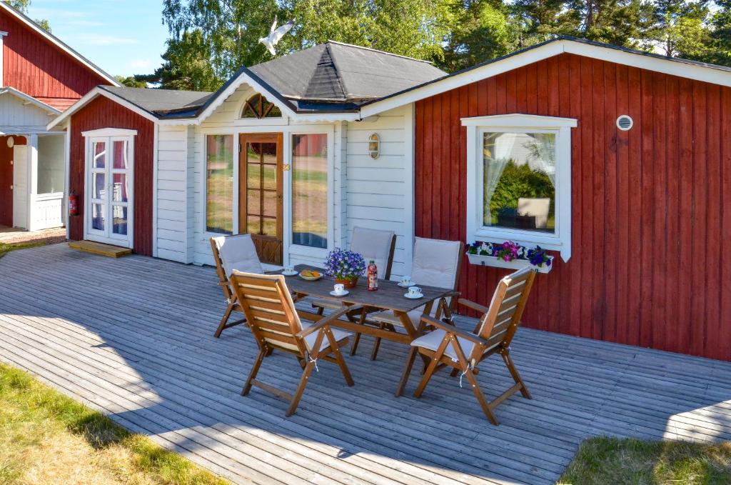 een patio met een tafel en stoelen en een gebouw bij Strandbergs Stugor in Mariehamn