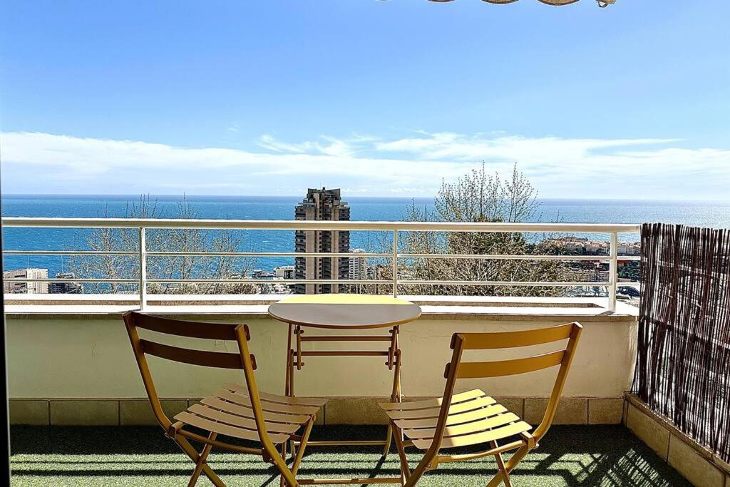 uma mesa e cadeiras numa varanda com vista para o oceano em Monte Carlo Vista - Vue Mer - Terrasse em Beausoleil