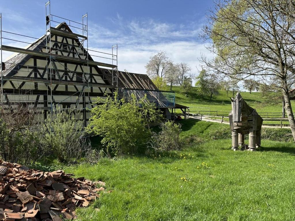 an old wooden house in a grassy field at Ferienhaus Gersmühle 