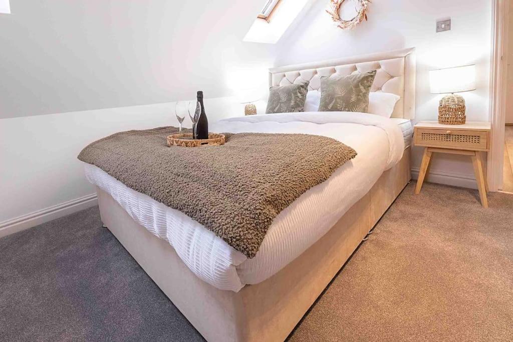 um quarto com uma cama grande e uma colcha branca em Bright 2-bed Flat in Central Reading em Reading