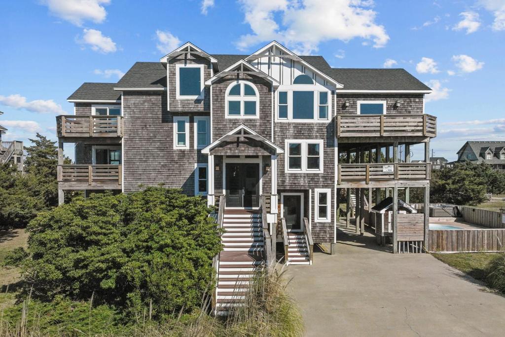 a large house with blue windows and a porch at 7015 - Nirvana by Resort Realty in Rodanthe