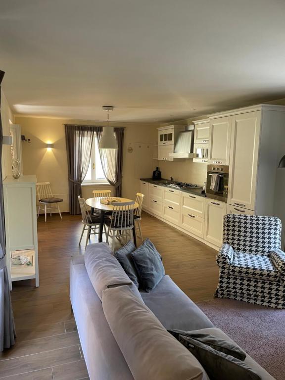 een woonkamer met een lange bank en een tafel bij Appartamento "Da Maddalena" in Menaggio