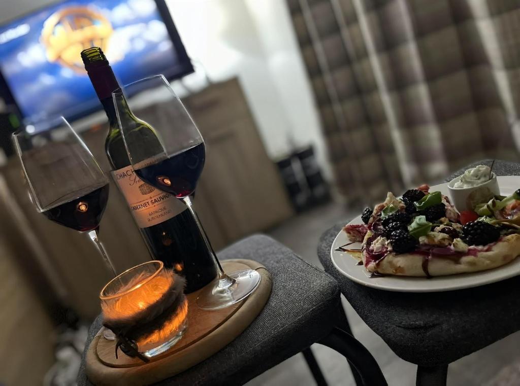 a table with two glasses of wine and a plate of food at Bear Hutte Saalbach near Billa in Saalbach Hinterglemm