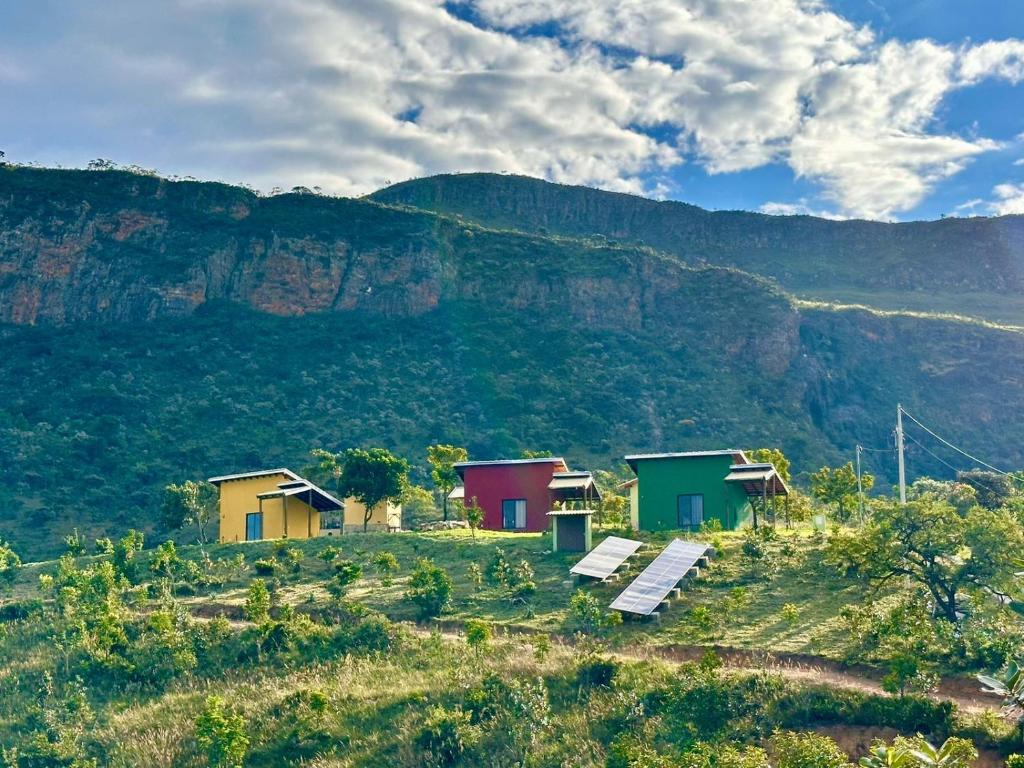 een groep huizen op een heuvel met een berg bij Canastra - Chalés Canário de Minas in São João Batista do Glória