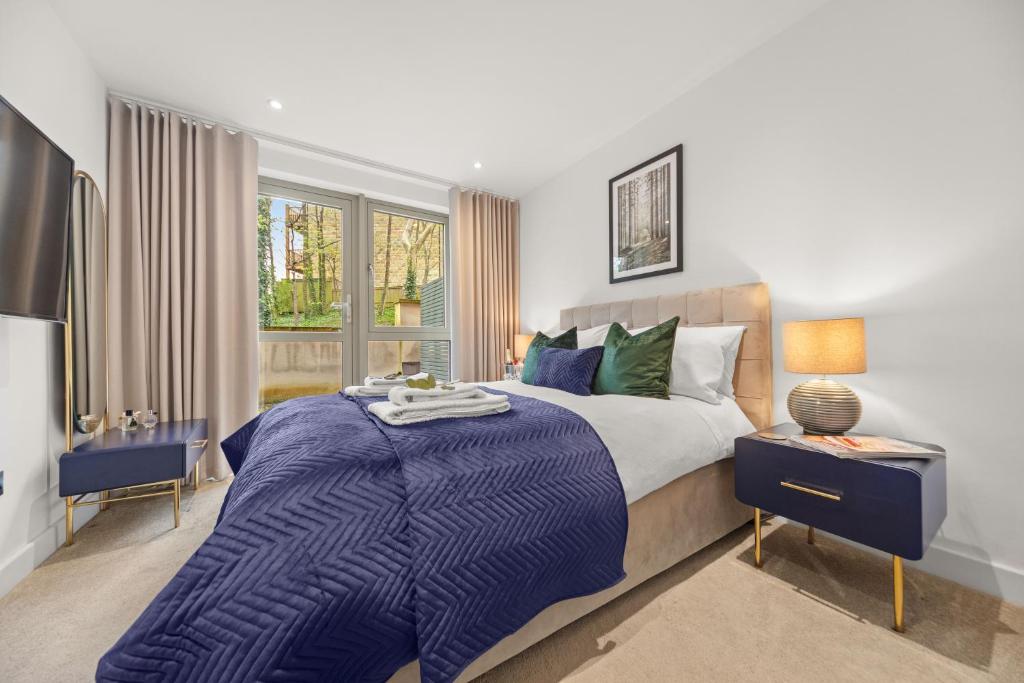 a bedroom with a large bed with a blue blanket at Springfield Two in Harrogate