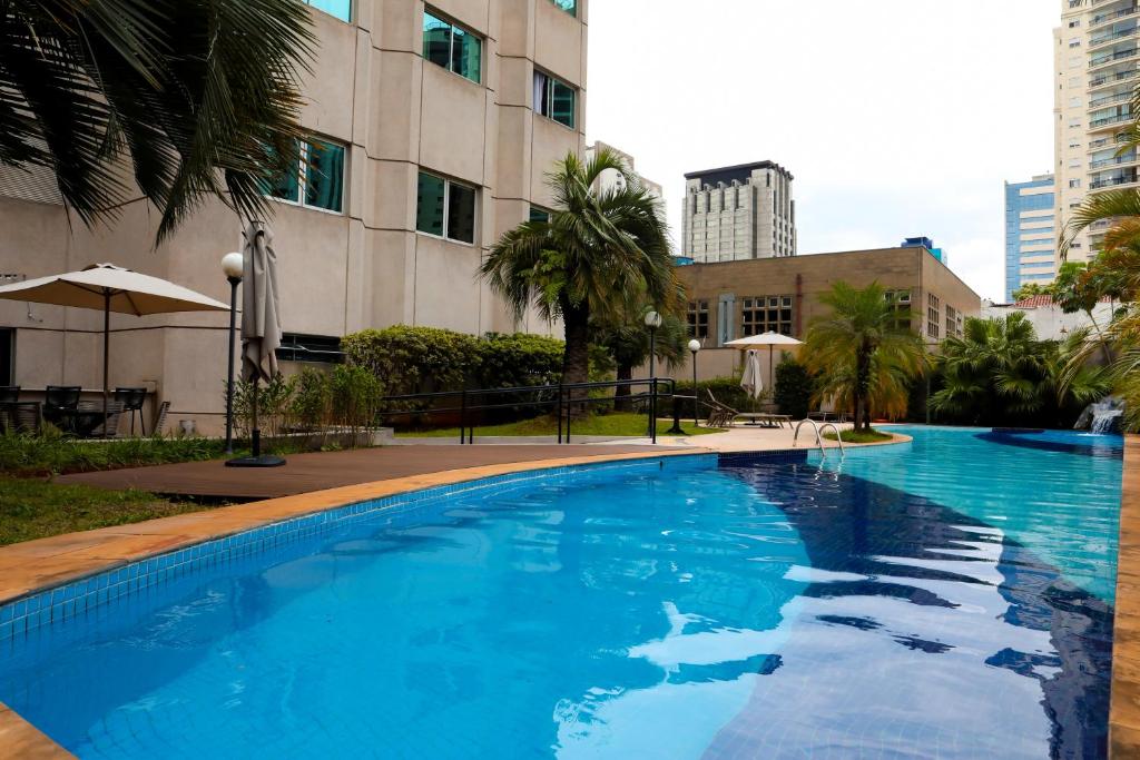 uma grande piscina azul em frente a um edifício em Intercity São Paulo Ibirapuera em São Paulo
