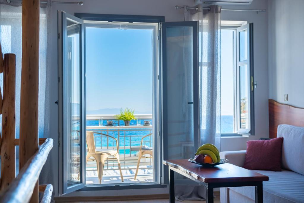 sala de estar con una puerta corredera de cristal que da a un balcón en A window to the Aegean, en Kokkari