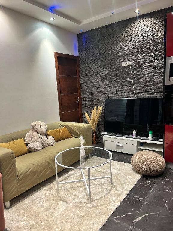 un ours en peluche assis sur un canapé dans un salon dans l'établissement Appartement Loft Lumière T2 à Ivry-sur-Seine, à Ivry-sur-Seine