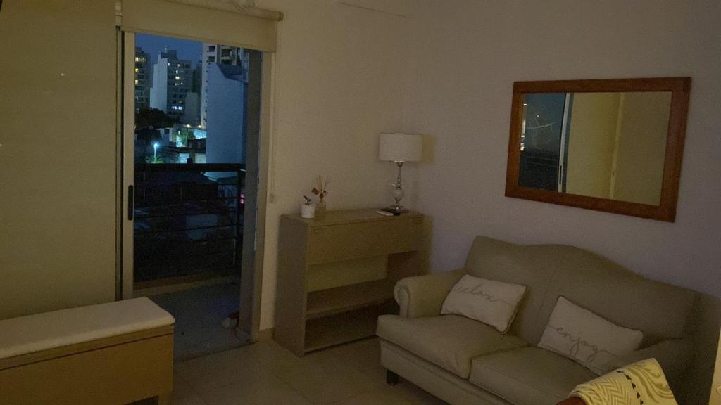 a living room with a couch and a chair and a window at Departamento temporario in Corrientes