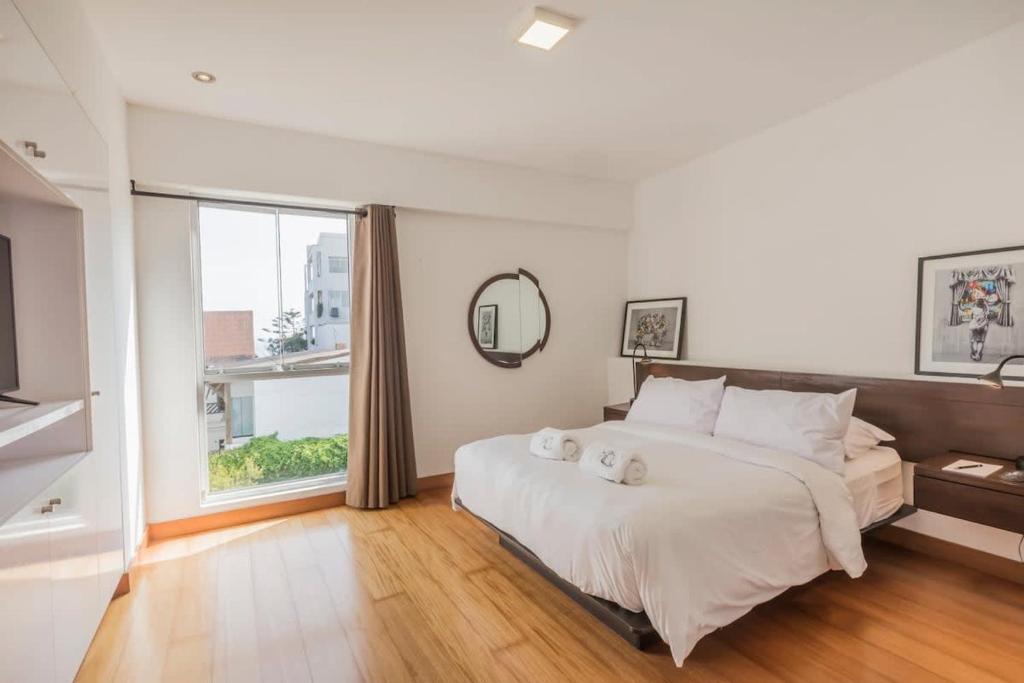 1 dormitorio con cama grande y ventana grande en Stylish 2BR at Malecon, en Lima