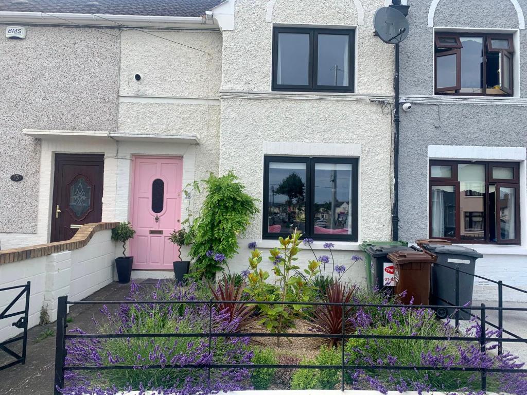 ein Haus mit einer rosa Tür und ein paar lila Blumen in der Unterkunft Townhouse near city centre in Dublin
