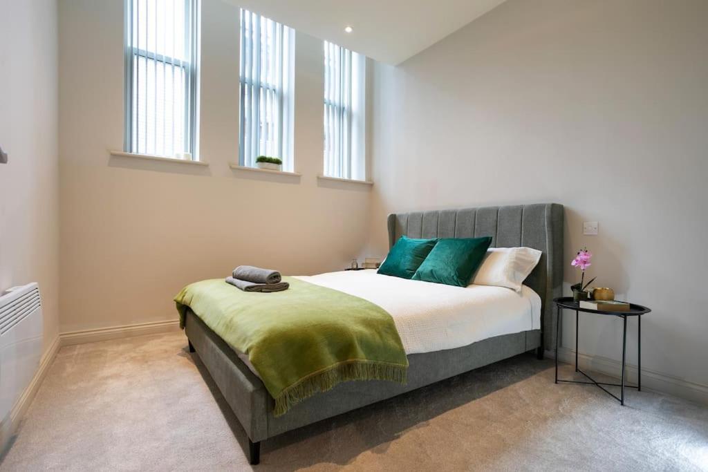 a bedroom with a bed with green pillows at Central Location, Stylish Apartment, Discounts in Leeds