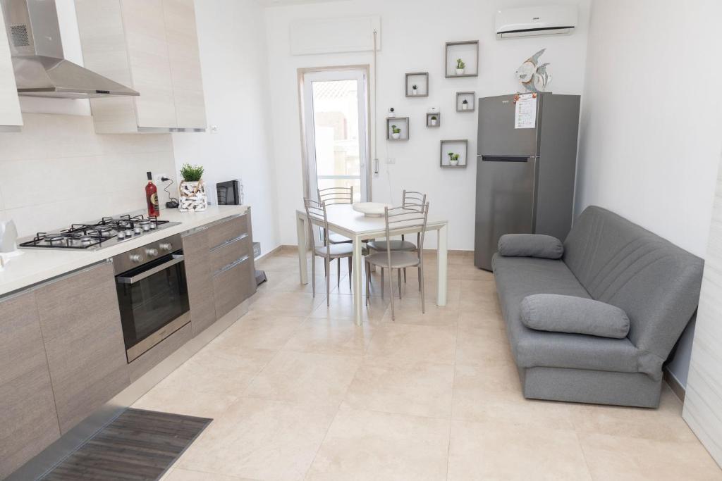 a kitchen and living room with a couch and a table at Casa BeFra Il relax che cercavi in Torre San Gennaro