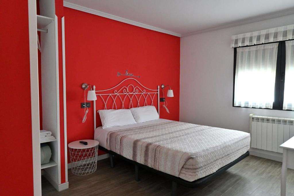 a red bedroom with a bed and a red wall at Apartamentos La Cueva - Onis in Avín