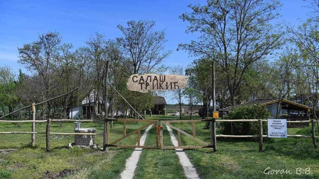 a sign for a farm with a fence at Salaš Trikić in Aleksandrovo