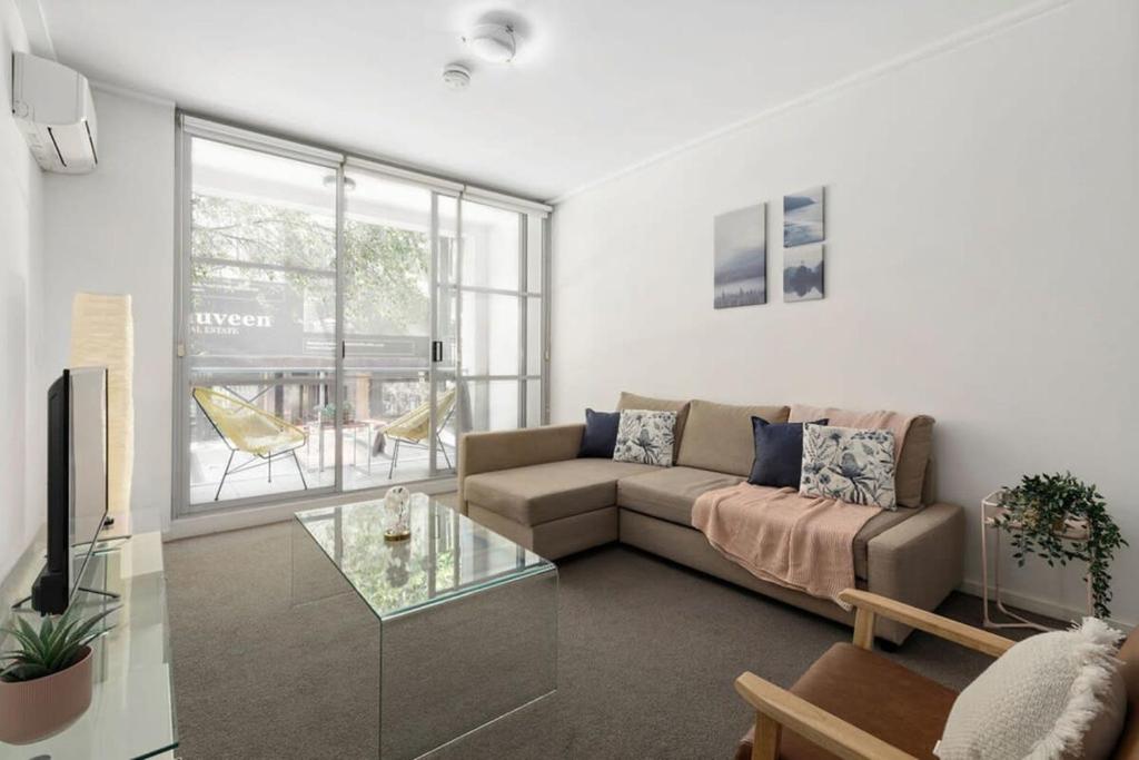 a living room with a couch and a glass table at A Modern & Cozy Studio Next to Darling Harbour in Sydney