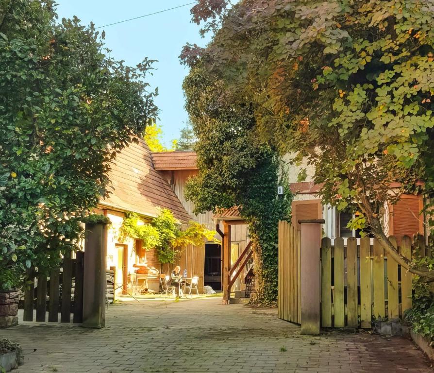 une maison avec une clôture en bois et une allée. dans l'établissement Ferienwohnungen auf einem ehemaligen Bauernhof, à Neuhausen