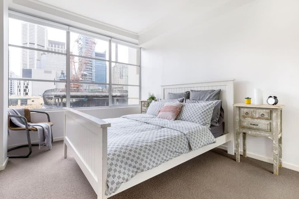 um quarto branco com uma cama e uma janela em NEW! A Comfy & Stylish Apt Next to Darling Harbour em Sidney