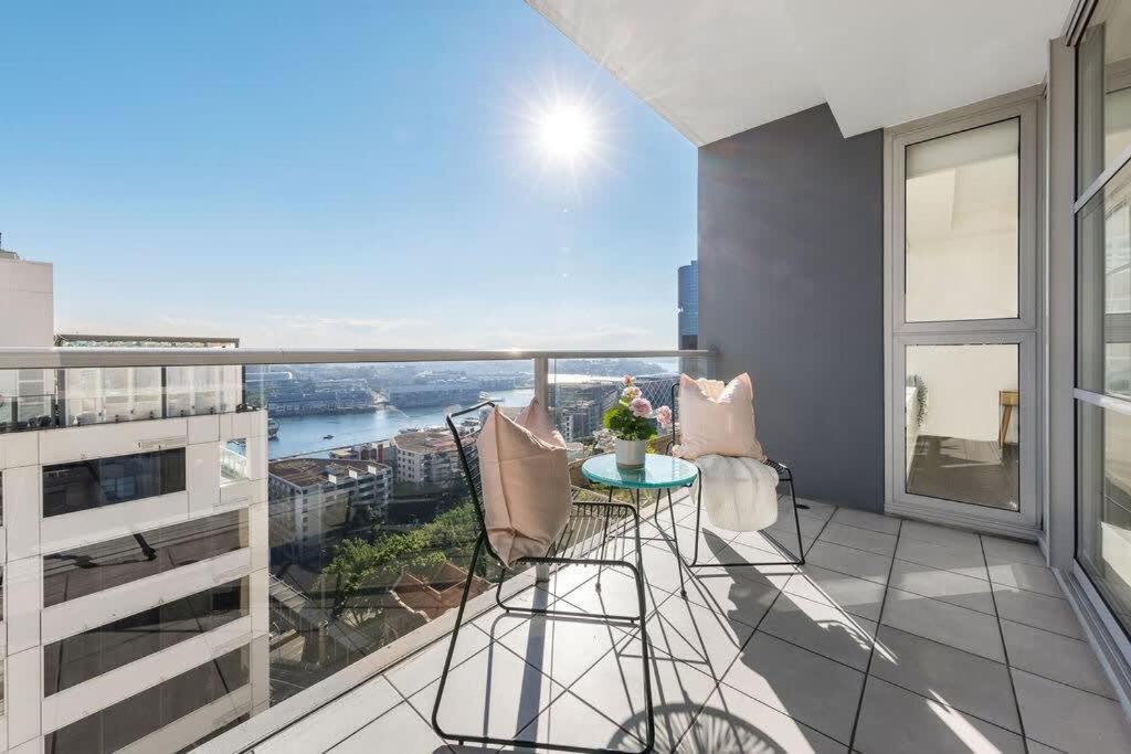 a balcony with a table and chairs on a building at A Spacious 2BR Apt with an Amazing View Over Darling Harbour in Sydney