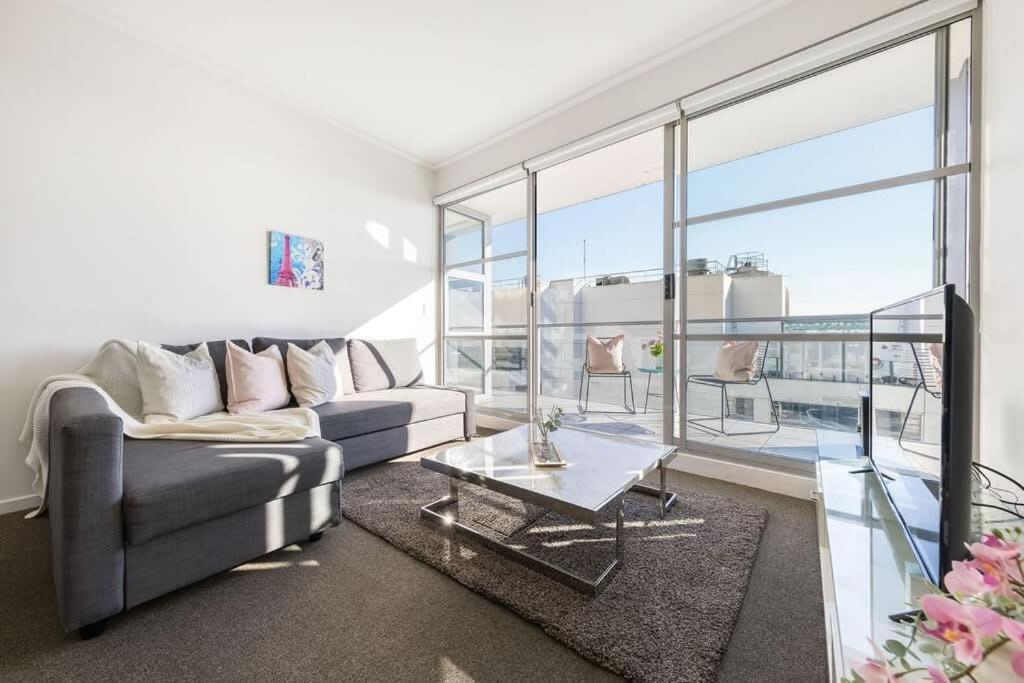 a living room with a couch and a table at A Spacious 2BR Apt with an Amazing View Over Darling Harbour in Sydney