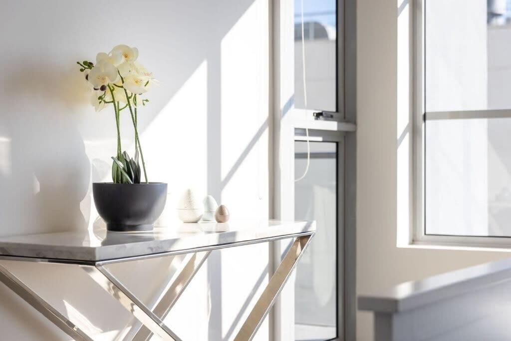 a glass table with a vase with flowers on it at A Spacious 2BR Apt with an Amazing View Over Darling Harbour in Sydney