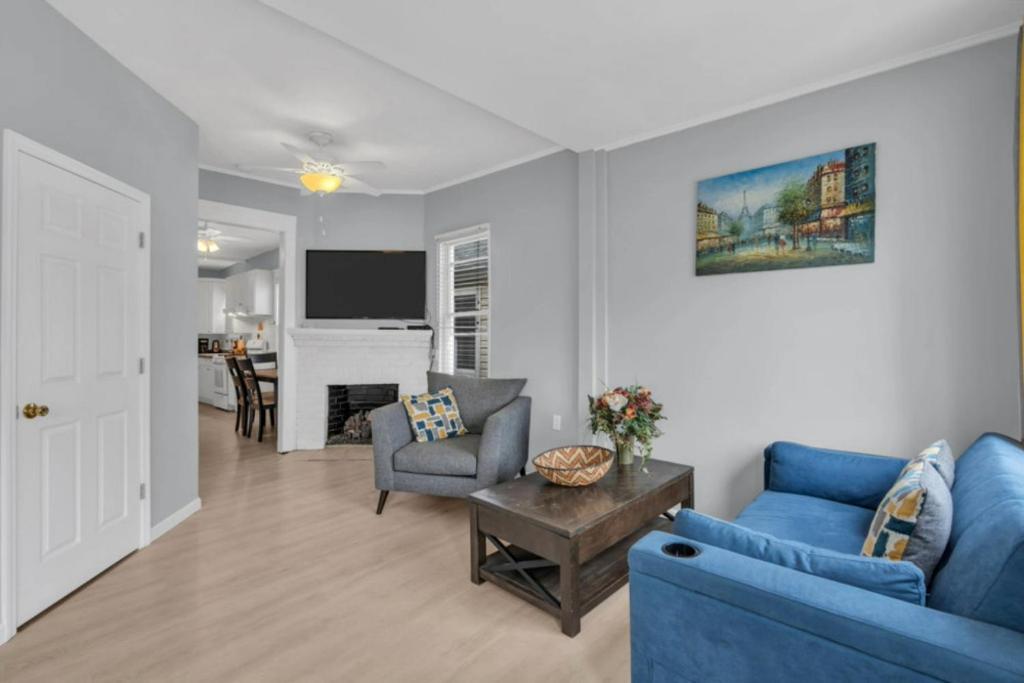 a living room with a blue couch and a table at Short Walk to the Beach! in Keansburg