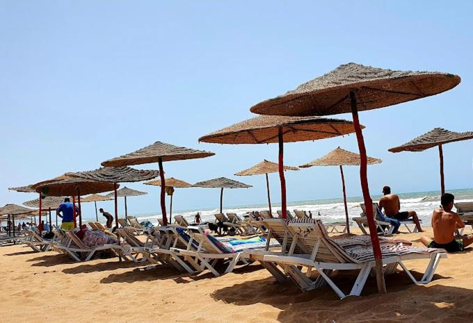 a group of chairs and umbrellas on a beach at sidi kaouki ayt karoum in Sidi Kaouki