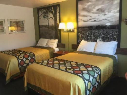 a hotel room with two beds and a painting on the wall at AINSWORTHINN in Ainsworth