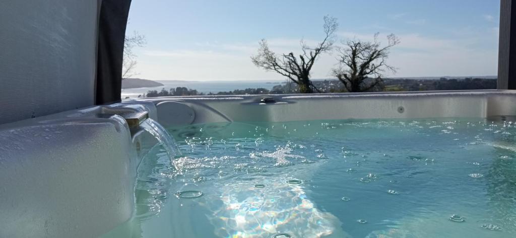 eine Badewanne mit Wasser aus der Badewanne in der Unterkunft Chambre avec terrasse privative et vue mer in Hanvec