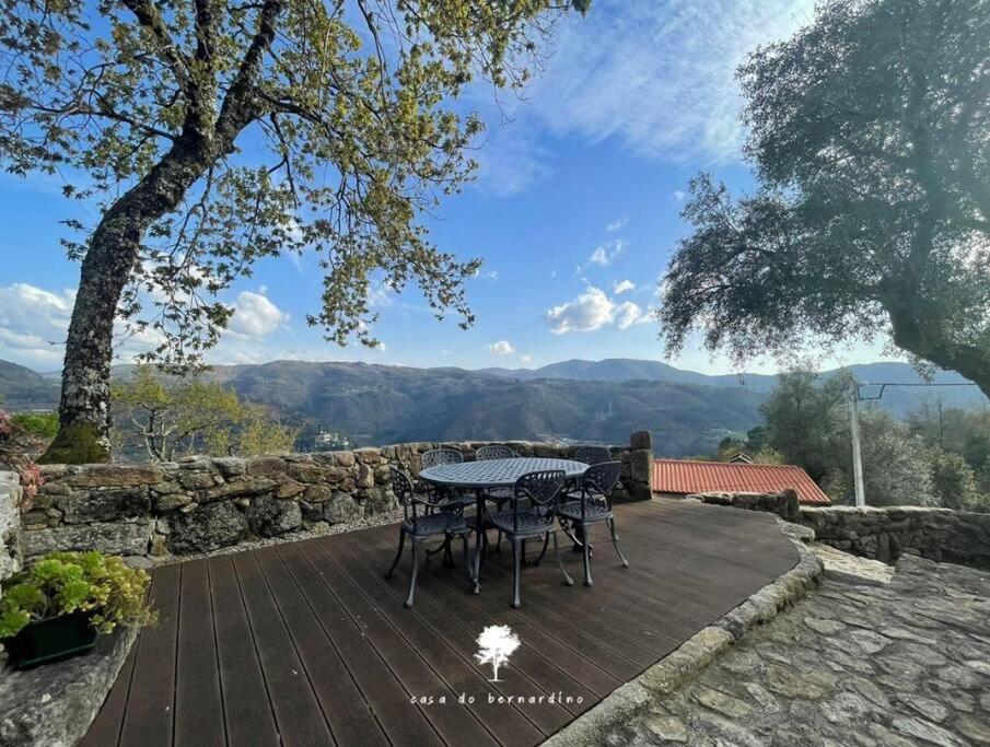 a table and chairs on a wooden deck with a view at Casa do Bernardino in Cabril