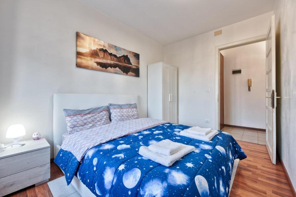 een slaapkamer met een blauw bed en handdoeken bij Midtown Garden City in Marghera