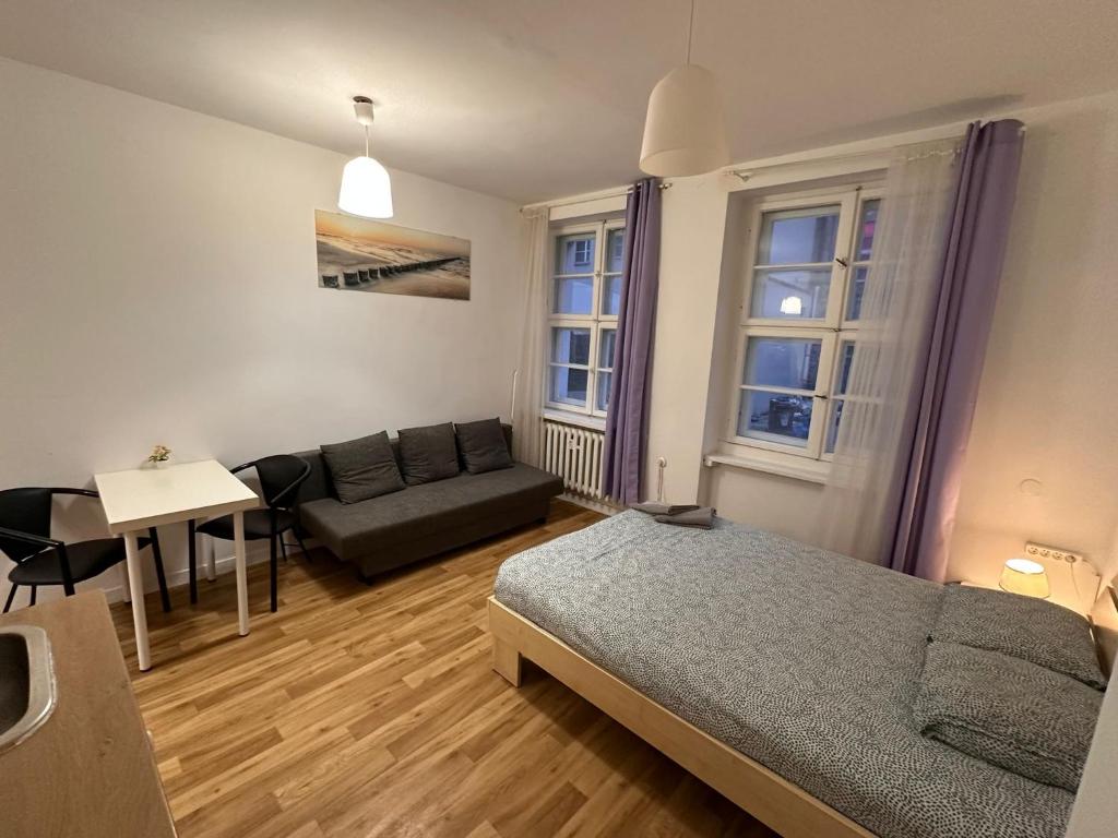 1 dormitorio con cama, sofá y mesa en Kozia 24/25, en Poznan