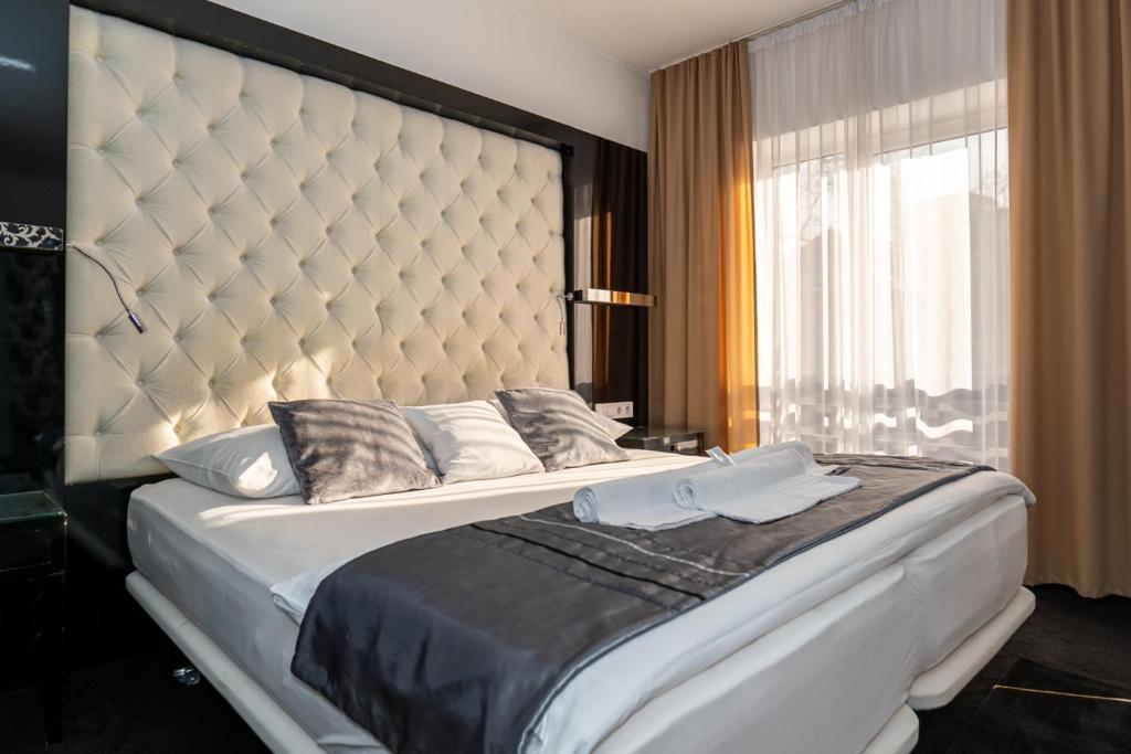 um quarto com uma cama grande e uma grande cabeceira. em Titan Centrum Apartman em Nyíregyháza