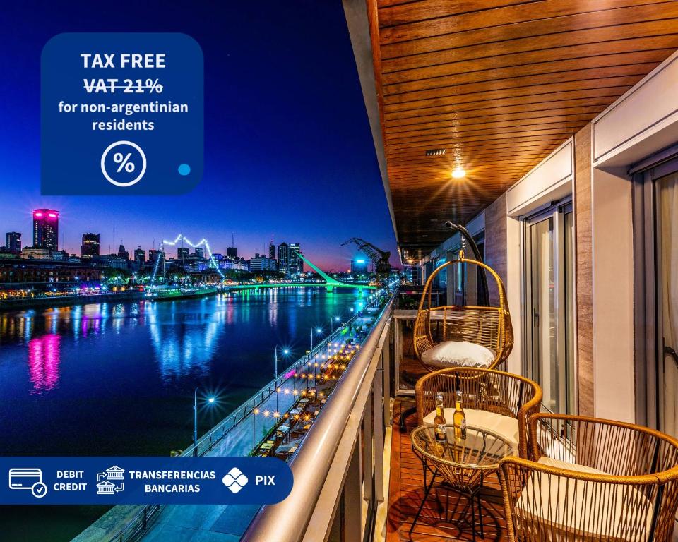 a balcony with chairs and a view of a river at Family Apartment with Puente de la Mujer View in Puerto Madero in Buenos Aires