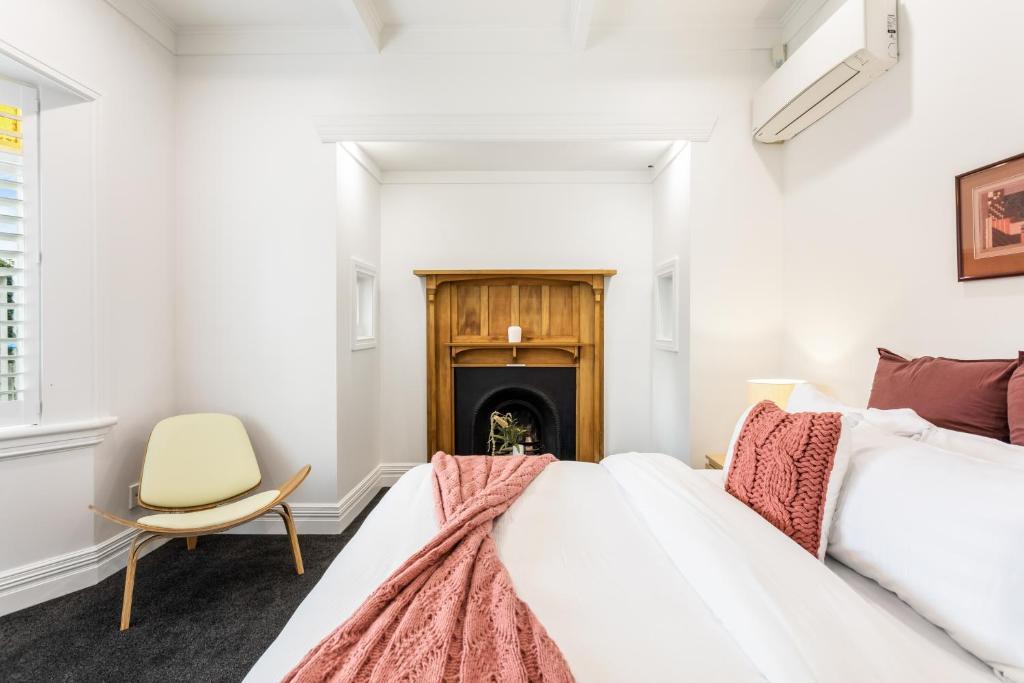1 Schlafzimmer mit 2 Betten und einem Kamin in der Unterkunft Beautiful Spacious 3BR in Auckland