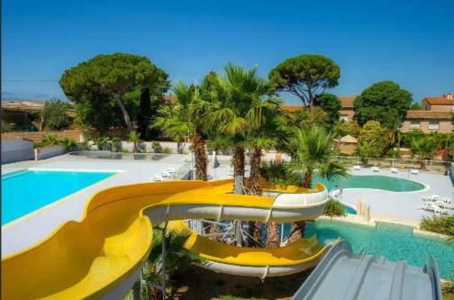 a resort with a slide and a swimming pool at Paisible camping les 7 fonds in Agde