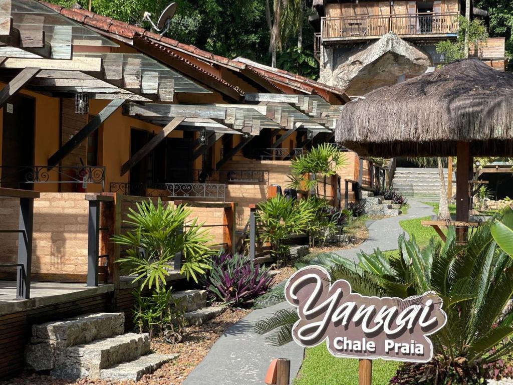a resort with a sign that says yamuna club path at Yannai Chalé Praia in Ilhabela