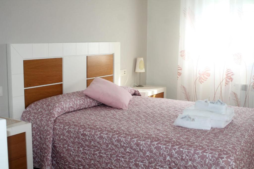 um quarto com uma cama com duas toalhas em A casa de Dora da Estrada em A Estrada