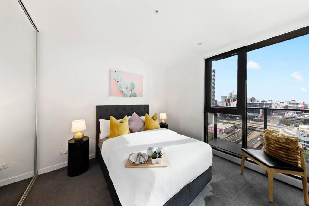 a bedroom with a bed and a large window at A Modern & Spacious 2BR Apt City Views Southbank in Melbourne