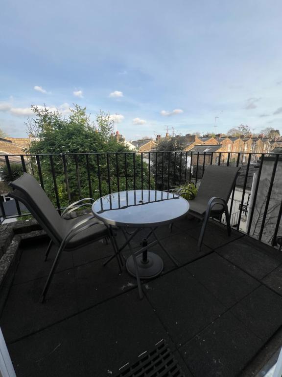 patio ze stołem i krzesłami na balkonie w obiekcie Sweet Homes w Londynie