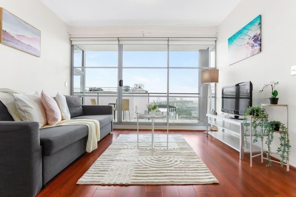 a living room with a couch and a tv at A Comfy 2BR Apt Harbour View FREE Parking in Sydney