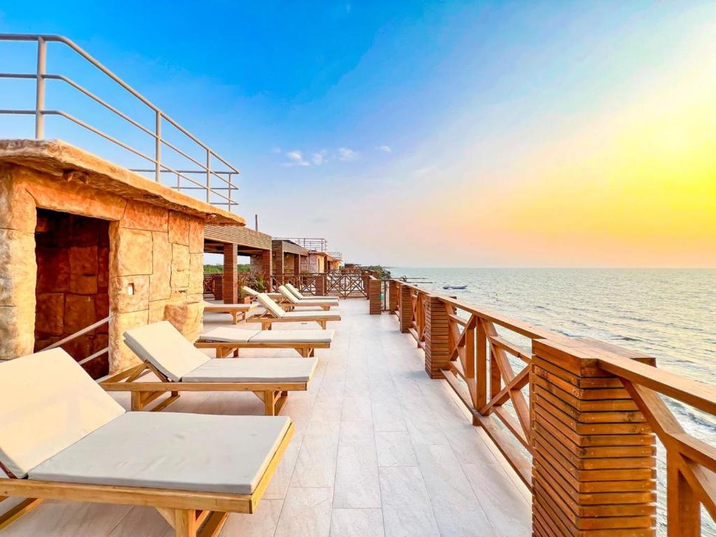 una fila di sedie e tavoli su un balcone affacciato sull'oceano di fantástico, paraíso, mar, atardeceres, playa, Paz a San Silvestre