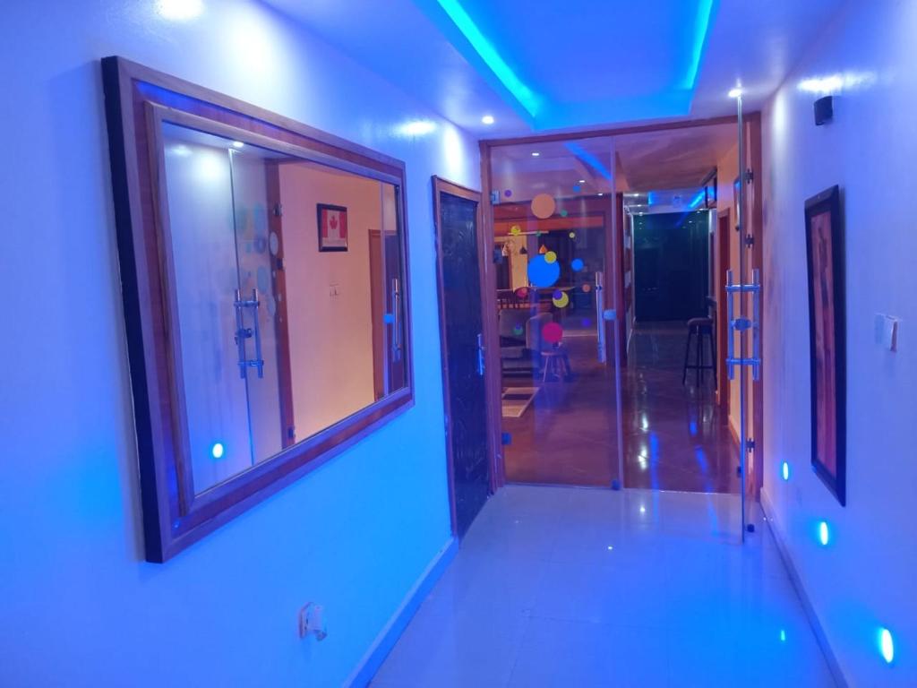 a hallway with three windows and a blue light at An Entire Rare Stylish 5-Bedroom Bungalow in Akure