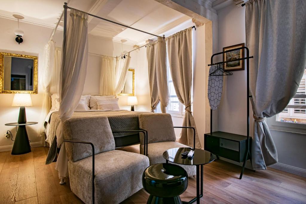 a bedroom with a canopy bed and a chair at Old Town City Center Apartments in Dubrovnik