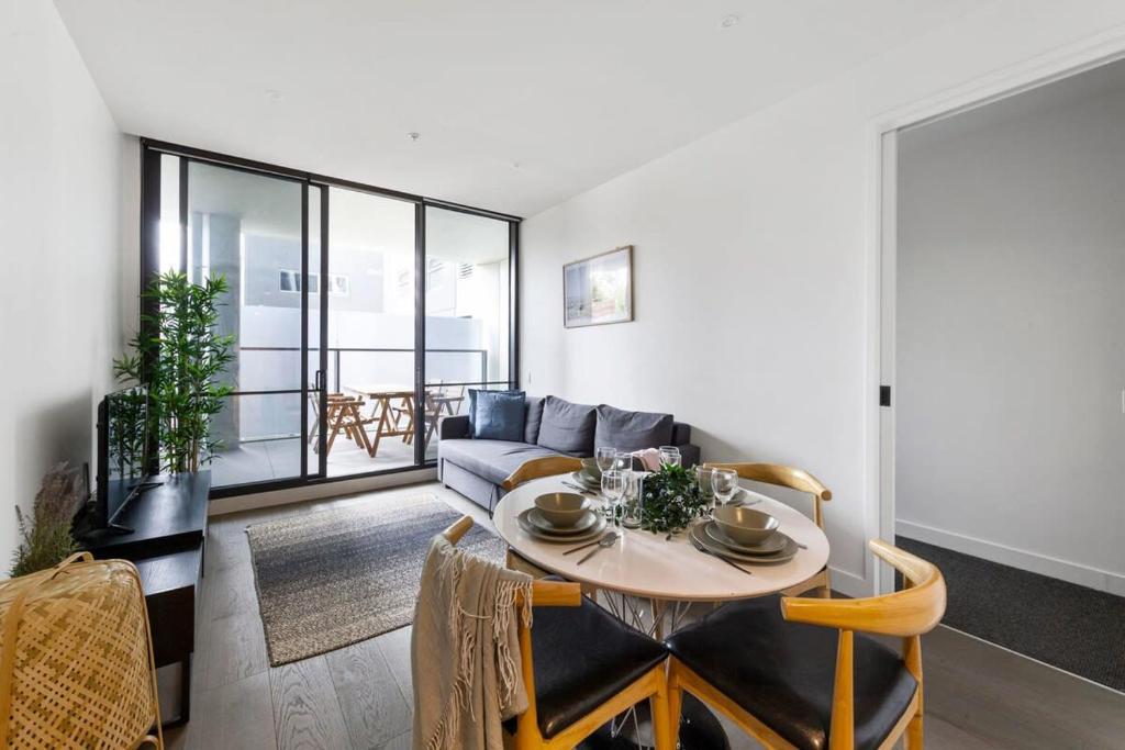 uma sala de estar com um sofá e uma mesa em A Stylish 2BR Apt Near Melbourne Central em Melbourne