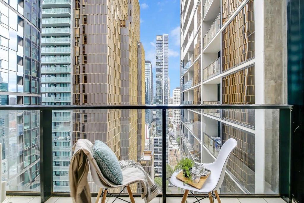 balcón con 2 sillas y vistas a la ciudad en A Comfy 2BR Apt Near to Melbourne Central, en Melbourne