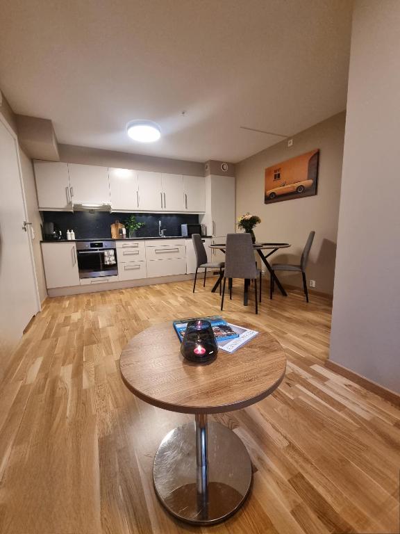 a living room with a table and a kitchen at Central Apartment Ålesund in Ålesund