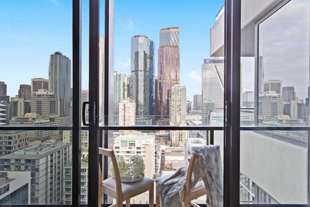 a view of a city skyline from a window at A Modern Apt Near Southern Cross with City Views in Melbourne